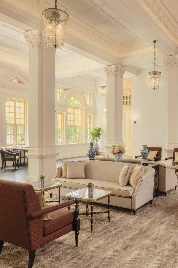 The interior of a lounge area in Raffles Hotel Singapore is full of natural light.